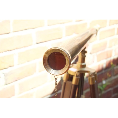 169A - A large brass cased telescope on adjustable wooden tripod stand, with lens cap on chain, 103cm