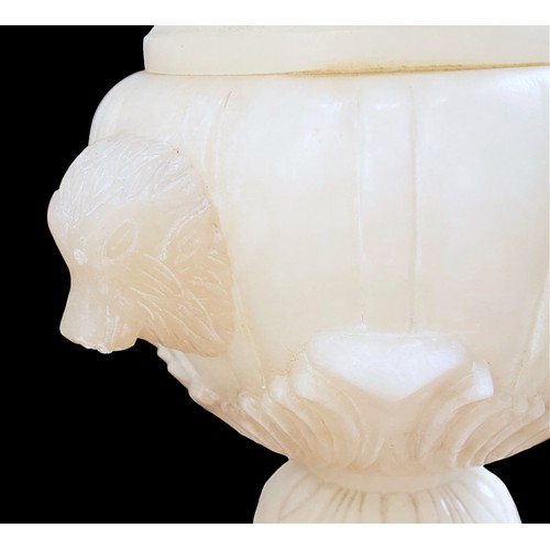 234B - (Damaged in transit) A carved alabaster urn, paired with and raised on sectional alabaster pedestal,... 