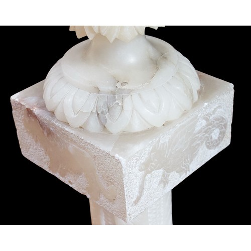 234B - (Damaged in transit) A carved alabaster urn, paired with and raised on sectional alabaster pedestal,... 