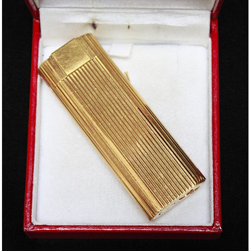 464 - A gold-plated Must de Cartier lighter, of rectangular form with rounded ends and reeded pattern to s... 