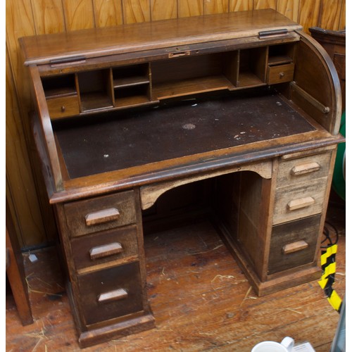 723 - A 1920s oak roll-top pedestal desk, with pigeonholes and two banks of three drawers, pull-out slide.... 