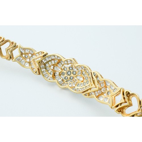 257 - An 18ct yellow gold bracelet, set with 91 x round brilliant cut diamonds, with a claw-set daisy clus... 