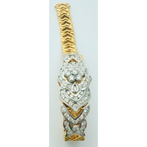 257 - An 18ct yellow gold bracelet, set with 91 x round brilliant cut diamonds, with a claw-set daisy clus... 