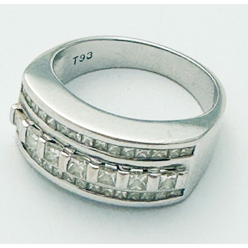 264 - An 18ct white gold wide band dress ring, bar-set with a row of seven princess cut diamonds to the ce... 