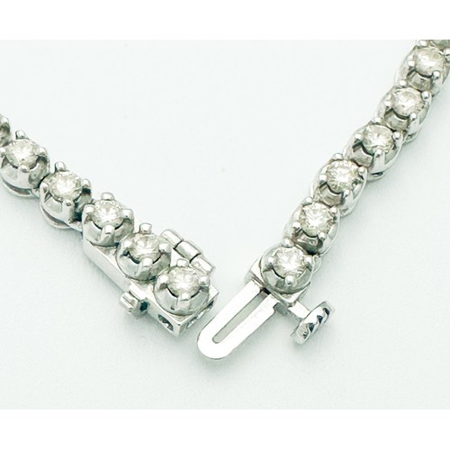 266 - An 18ct white gold line necklace, claw set with 119 x round diamonds, graduating in size, total diam... 