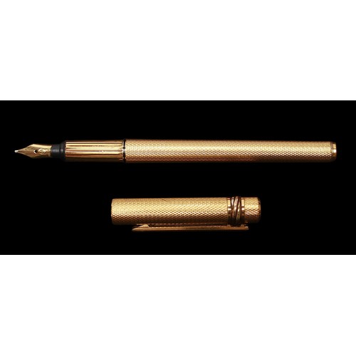 470 - A gold-plated Must De Cartier fountain pen, with engine turned decoration to shaft and lid and an 18... 