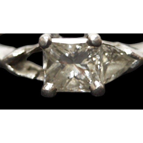 274 - A platinum and diamond ring, centrally set with a princess cut diamond, flanked by a trillion cut di... 