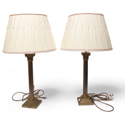 573 - A pair of brass table lamps modelled as Clasical columns with composite capitals, and two smaller br... 