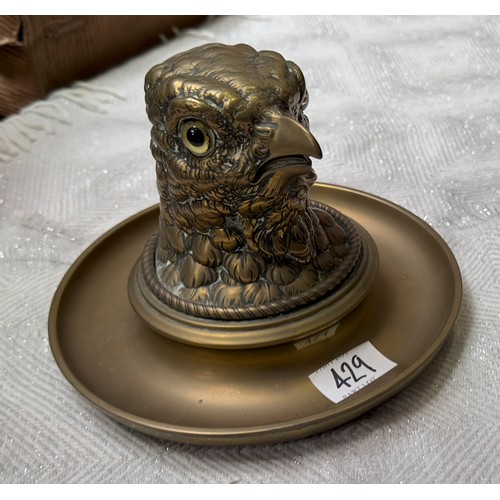 429 - A brass inkwell and ashtray with glass liner, modelled as the head of an eagle with glass eyes, appr... 