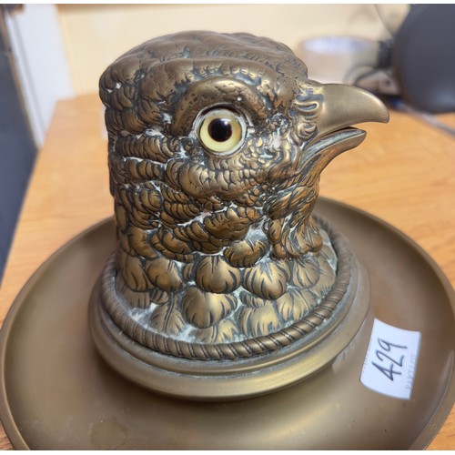 429 - A brass inkwell and ashtray with glass liner, modelled as the head of an eagle with glass eyes, appr... 