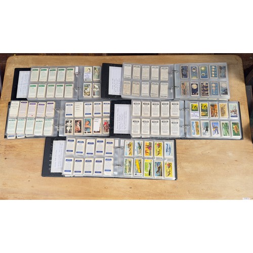 553 - A large quantity of cigarette cards and tea cards in twelve ring-binders with clear vinyl pockets, i... 