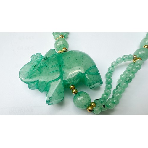 83 - A green jade bead necklace with carved jade lucky elephant, 32 inches in length, together with a gre... 