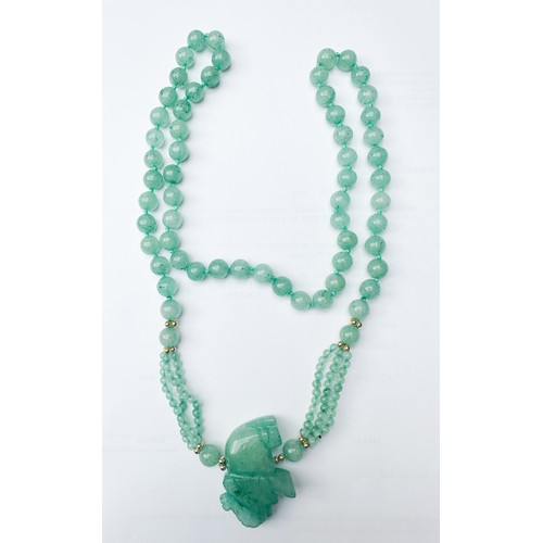 83 - A green jade bead necklace with carved jade lucky elephant, 32 inches in length, together with a gre... 