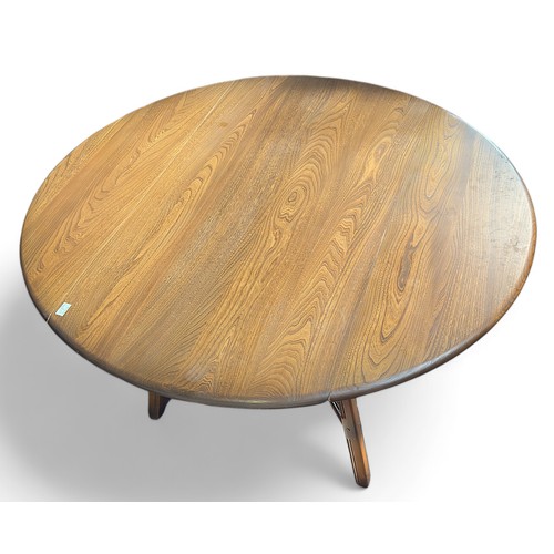 147 - An Ercol golden dawn elm drop-leaf table, raised on squared supports with x-stretcher, 113cm wide