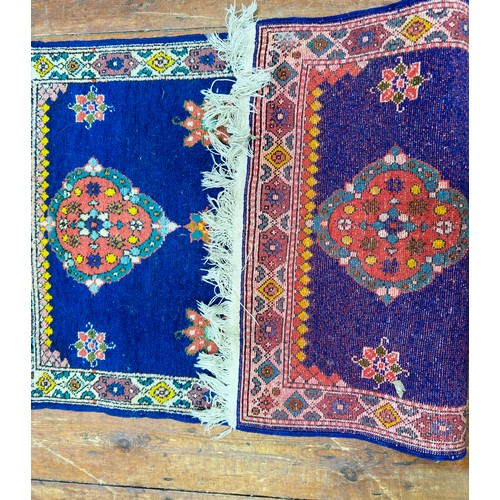 131 - A hand-knotted rug with three central guls and stylised flowers to a deep blue field, within stylise... 