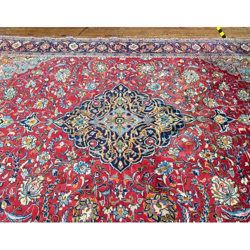 134 - A Persian medallion carpet with red central field, blue spandrels within blue Shah Abbas border, 348... 