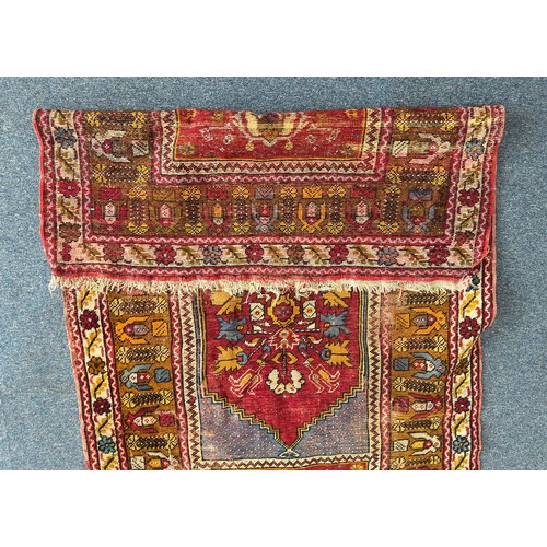 136 - A hand-knotted Caucasian rug, worked with central red gul within stylised multi-borders, 162cm x 105... 