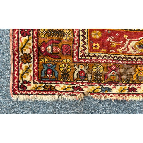 136 - A hand-knotted Caucasian rug, worked with central red gul within stylised multi-borders, 162cm x 105... 