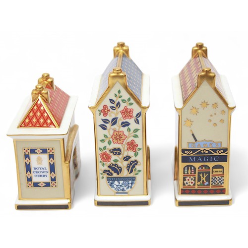 271 - Five assorted Royal Crown Derby paperweights modelled as shops and houses, each with white stopper, ... 