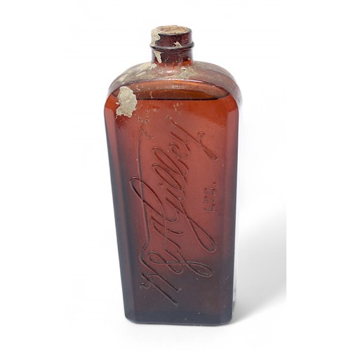 228 - An amber glass bottle of W & A Gilbey Gin, circa 1940s, sealed, cork in tact, coffin shaped bottle e... 