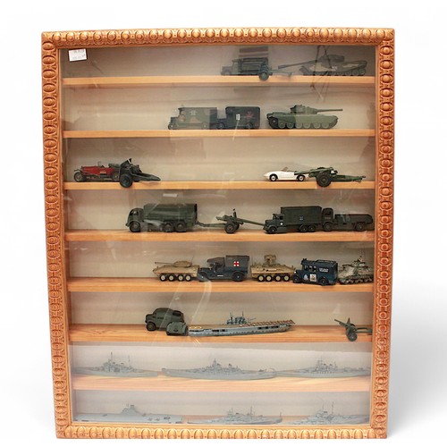 49 - A glazed wooden display containing a collection of military vehicles, and battleships etc.  77x63cm