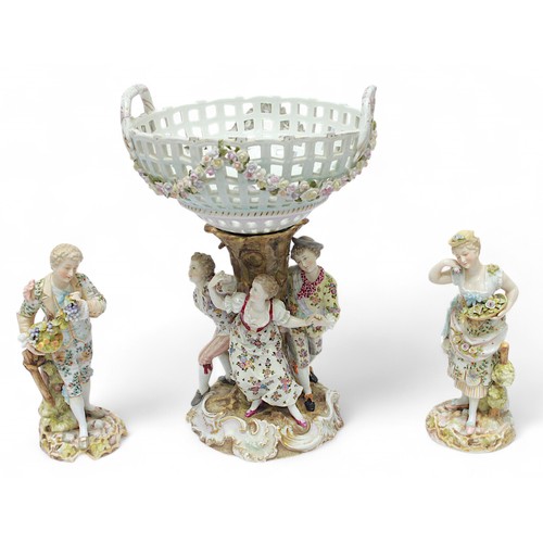 302 - A Sitzendorf porcelain comport, with pierced, floral encrusted top section, raised on figure-group s... 