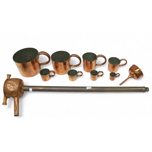 94 - A matched set of eight graduated, round copper rum measures, from 1/2 gill to a gallon, with a spiri... 