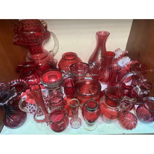 64 - A very large collection of assorted Cranberry coloured glass, comprising jugs, vases, bowls, etc., i... 