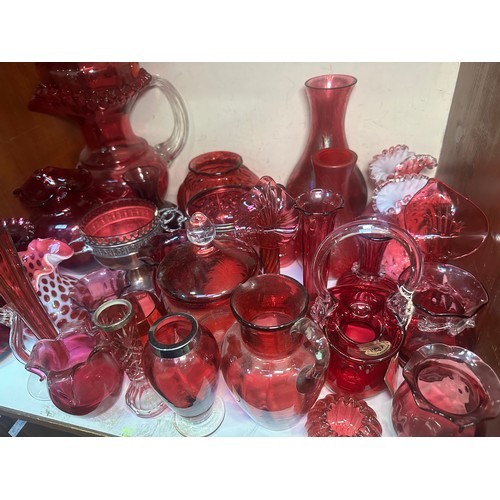 64 - A very large collection of assorted Cranberry coloured glass, comprising jugs, vases, bowls, etc., i... 