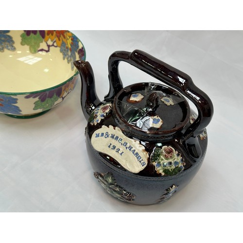 109 - A 'Bargeware' treacle glaze teapot, dated 1921, together with a Royal Doulton 'Gloria' pattern rose-... 