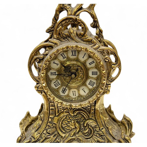 93 - A 20th Century brass clock garniture, the pierced brass and white enamel dial with Roman numerals de... 