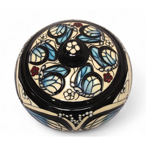 122 - A Moorcroft pottery pot and cover decorated with butterflies amidst flowers, designed by Rachel Bish... 