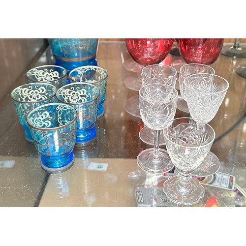 136 - A set of six cranberry glasses, a blue glass liquor set, some Dartington glasses and Webb crystal cu... 