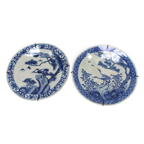 161 - A near pair of Chinese porcelain wall chargers, each decorated in cobalt blue under a crackle glazes... 