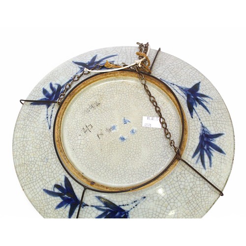 161 - A near pair of Chinese porcelain wall chargers, each decorated in cobalt blue under a crackle glazes... 