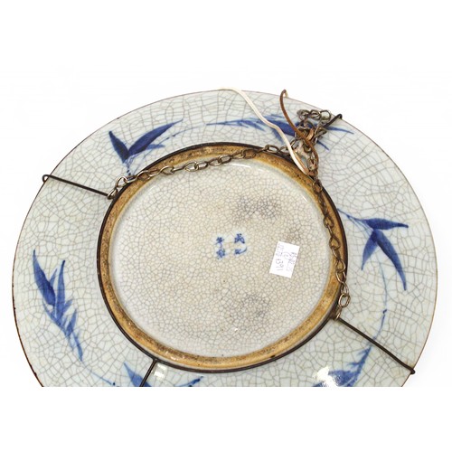 161 - A near pair of Chinese porcelain wall chargers, each decorated in cobalt blue under a crackle glazes... 