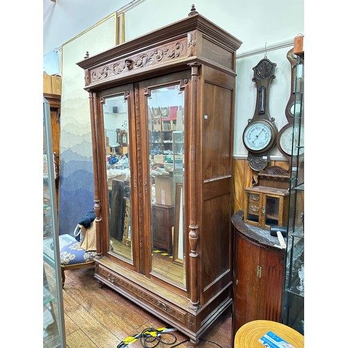 651 - A French oak armoire, the cornice with carved frieze, above a pair of mirrored doors, flanked by flu... 