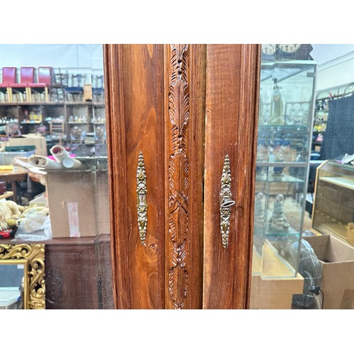 651 - A French oak armoire, the cornice with carved frieze, above a pair of mirrored doors, flanked by flu... 