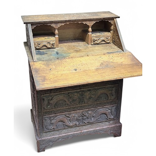 549 - A heavily carved late 19th / early 20th century Chinese hardwood bureau, with hinged sloped front en... 