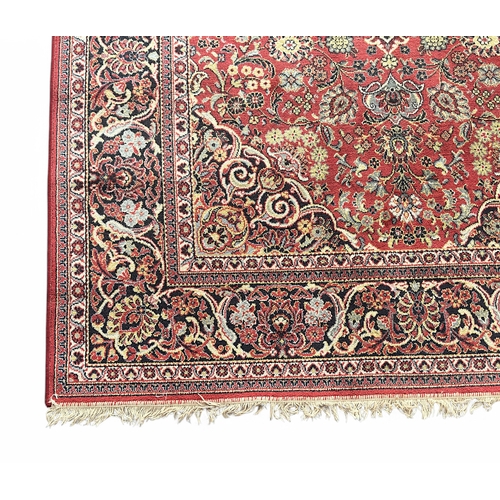 487 - A hand-knotted woollen rug, of Persian style with central medallion to a red field within Shah Abbas... 