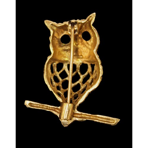 222 - A 9ct gold brooch modelled as an owl perched on a branch, with pierced body and black faceted eyes. ... 