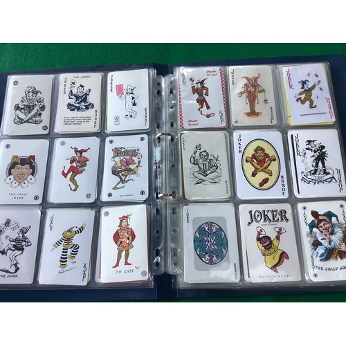 370 - An album containing 198  colourful jokers from packs of playing cards – plus another 124 loose  joke... 