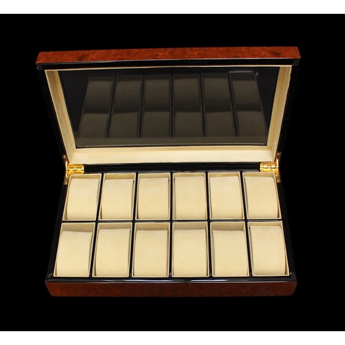 205 - A burr walnut effect 12 watch display box by Rapport, with glazed cover enclosing lined, compartment... 