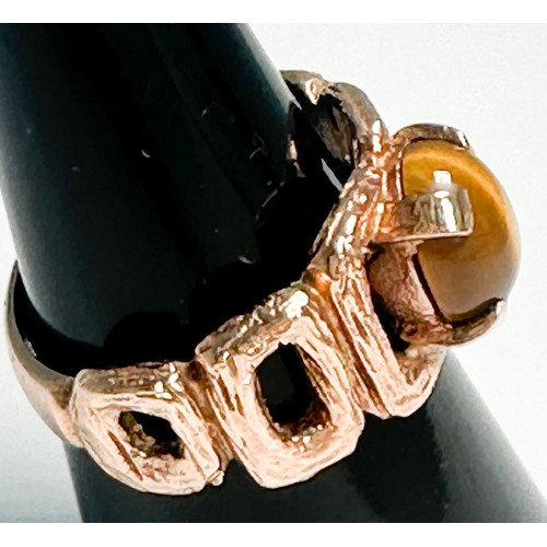 245 - A 9ct rose gold dress ring, four-claw set with an oval shaped tigers eye to the centre, measuring 9m... 