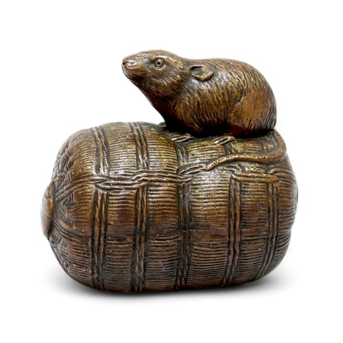 146 - A Japanese Bizen ware pottery model of a rat stood on a bale of rice. 13cm long.