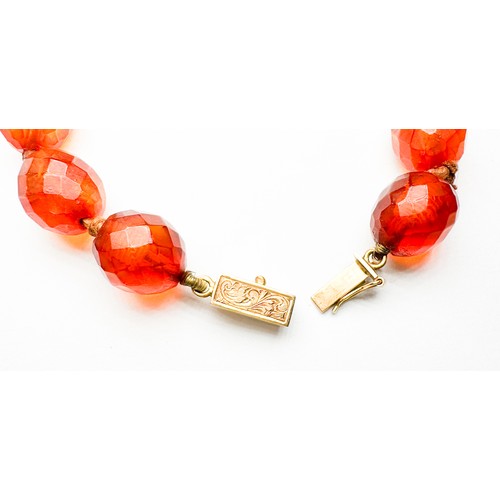 281 - A graduated, faceted amber necklace, measuring 20 inches in length, largest central bead approximate... 