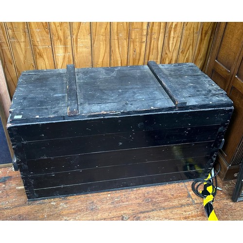 583 - A black painted wooden trunk, with planked top and sides, 110cm long, together with a smaller black ... 