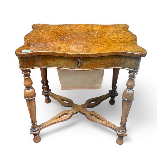 585 - A walnut work table, with hinged serpentine top, enclosing a compartmented interior, with well secti... 