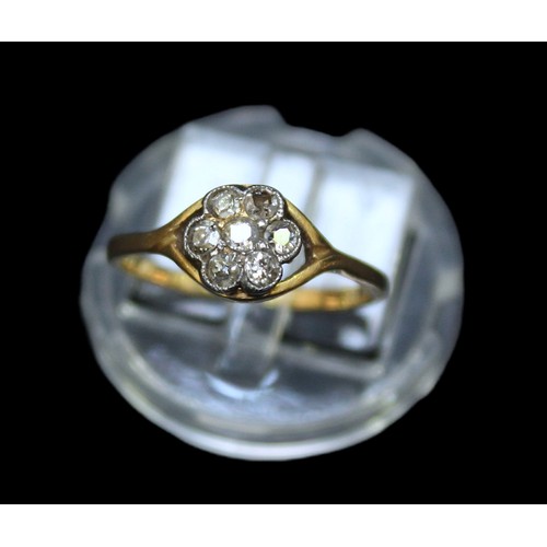 285 - An 18ct gold diamond daisy cluster ring, milligrain set with seven old round faceted cut diamonds, e... 