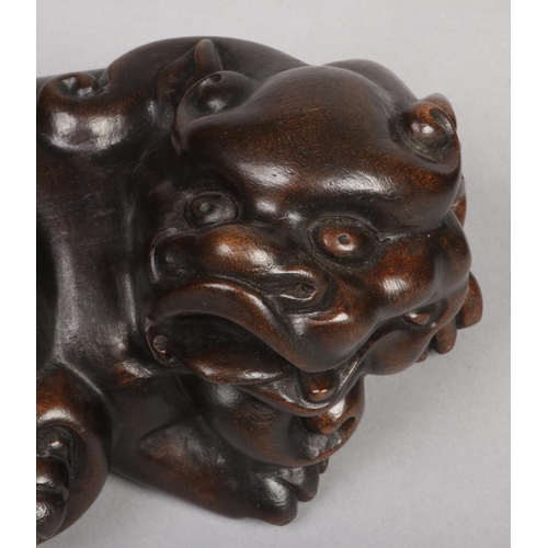 181 - A pair of Chinese carved hardwood lion dogs in recumbent pose c.1900, 22cm.